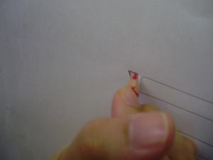 原稿の切れ込みから鉛筆で壁面に印を付けている様子