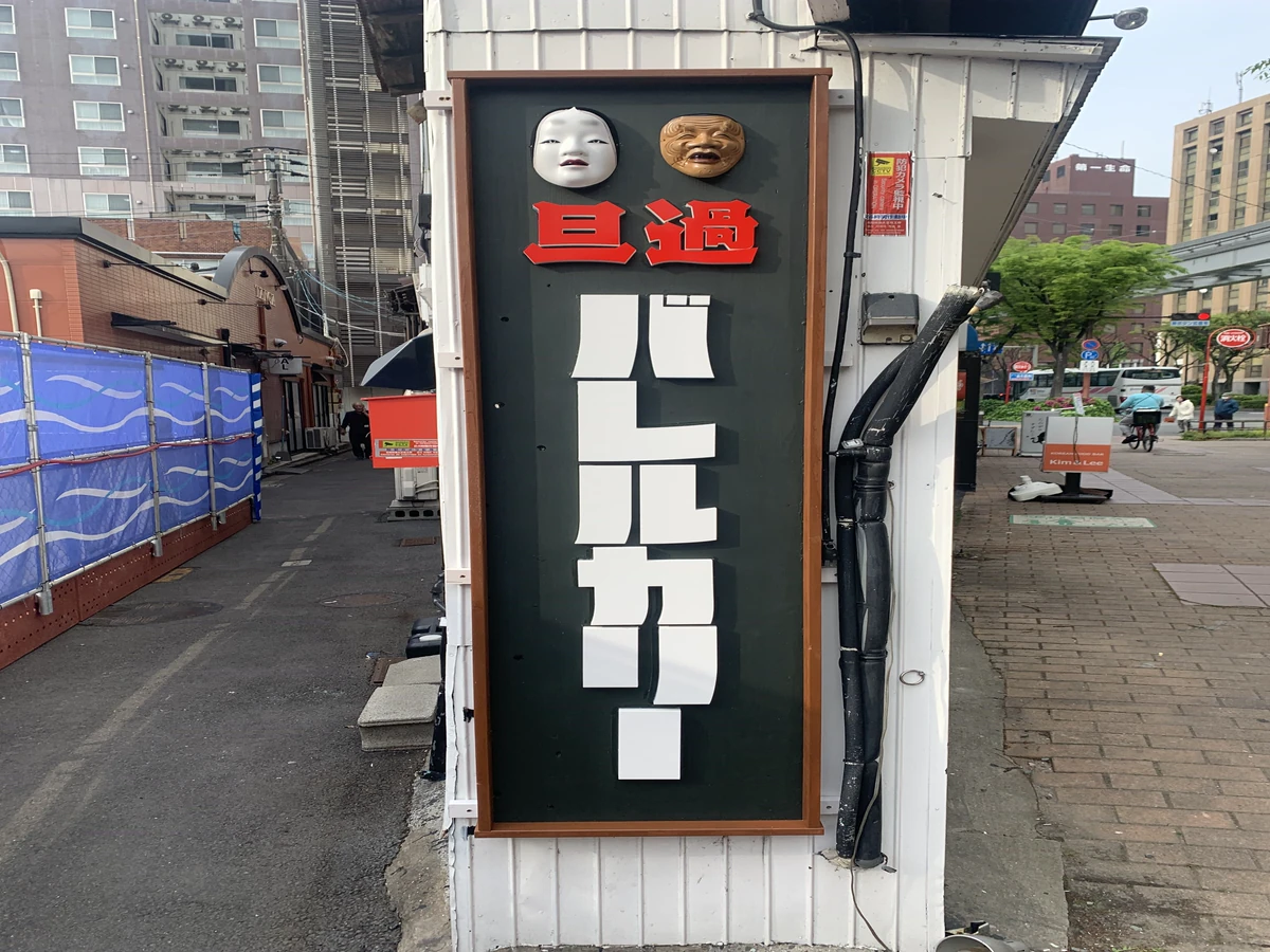 店舗の縦長の看板に取り付けられた赤と白のカルプ文字