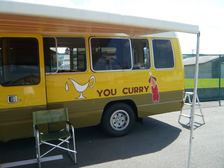 黄色いキッチンカーの車体に貼ったロゴとキャラクターのプリントステッカー