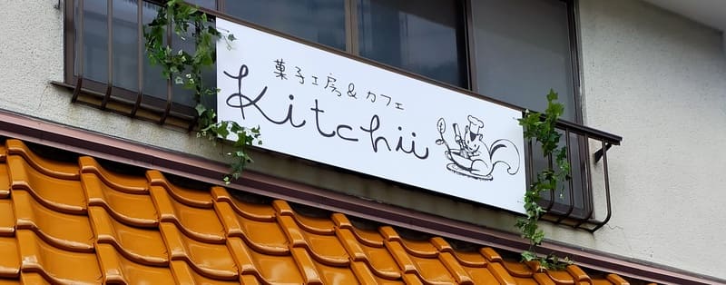 菓子工房とカフェの建物に設置された白いプレート看板